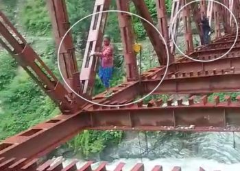 जान जोखिम में डालकर निर्माणाधीन पुल से नदी पार कर रहे ग्रामीण।